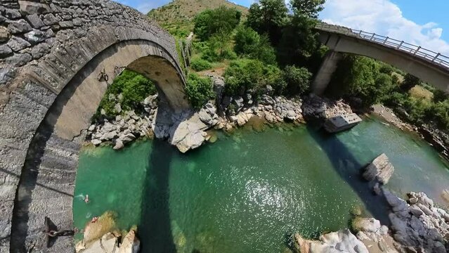 Drone view of the Mesi Bridge, located in Albania, is an architectural gem that spans the Kir River in the picturesque village of Mesi. This historic stone bridge, dating back to the Ottoman period.