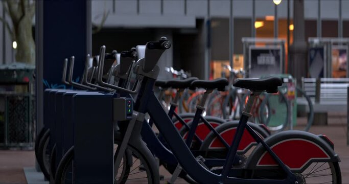 Row of Green bicycles for rent. Electric bicycle charging station. Shared electric bikes parked on city street