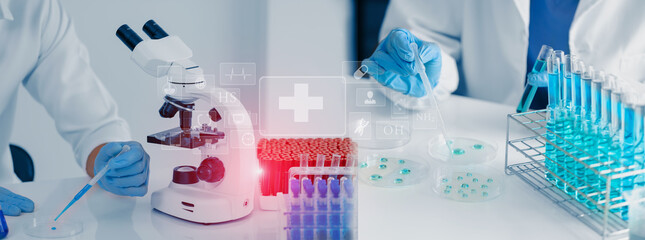 Professional scientist looking through a microscope in a laboratory with blood samples or tests, Science, analysis and medical technology concept.