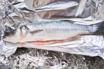 Salmon whole fish on foil ready for baking in the oven. Healthy food cooked at home. Restaurant menu, a series of photos of different dishes