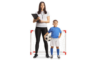 Boy with a female football coach posing in front of a mini goal