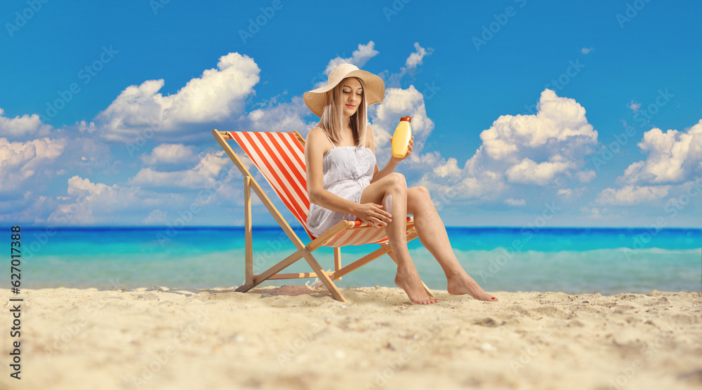 Poster woman sitting on a deck chair and applying sun cream on legs