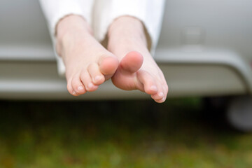 Feet of a child sitting in the trunk of a car