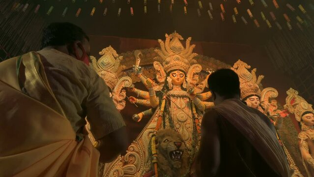 Howrah, West Bengal, India - 3rd October, 2022 : Hindu Priests worshipping Goddess Durga with white conch shell. Ashtami puja aarati - sacred Durga Puja ritual - fetival of Hinduism, at night.