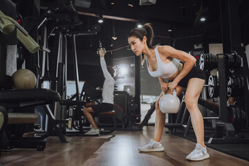 Fototapeta na wymiar Workout, Fitness workout in gym with trainer assisted in training, Fitness concept, Fit asian woman, Young white man and asian girl exercising in the gym.