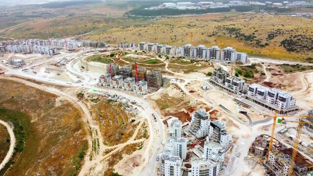 Modiin, Israel, January 12, 2023. aerial view of the construction of infrastructure and a new residential area. Operation of tower cranes and construction equipment. High-quality 4k footage