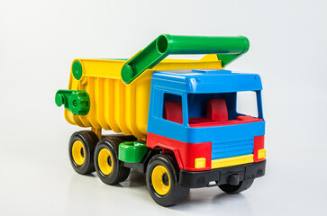 Multi-colored plastic toy trucks for children's games on a white background. Dumper.