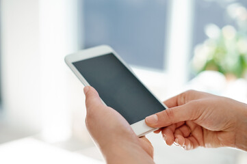 Modern business requires modern technology. Cropped shot of an unrecognizable businesswoman using her smartphone inside of an office.