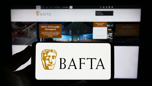 Stuttgart, Germany - 07-14-2023: Person holding smartphone with logo of British Academy Film Awards (BAFTA) on screen in front of website. Focus on phone display.