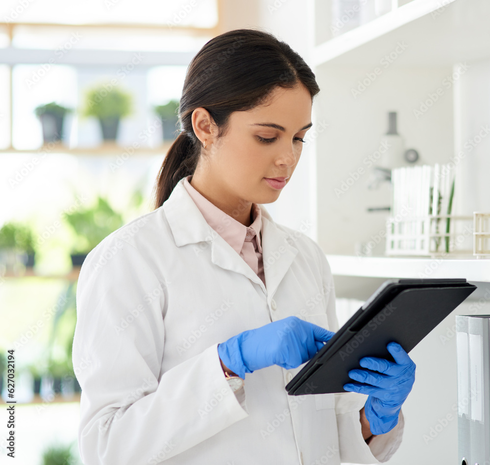 Poster digitising her scientific tasks. shot of a young scientist using a digital tablet in a lab.