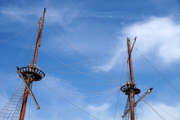 masts of a vintage ship on a sunny cloudy sky