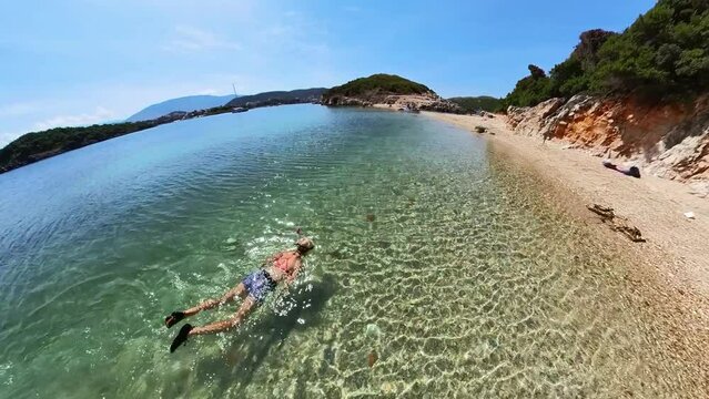 drone view of girl swimming in beach Ksamil Islands. Popular tourist destination, especially busy during summer months.