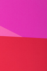 Multicolor background from a paper of different colors. Mix of pink, red and purple colors. Geometric backdrop.