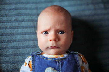 Funny baby 3 months old with a serious face