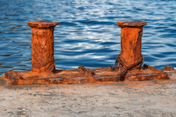 Marine bollard for mooring old rusty on background of the sea