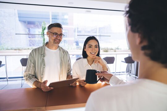 Happy multiracial couple at reception in modern hotel