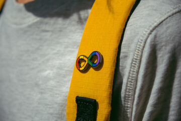 Kid with backpack with autism infinity rainbow symbol sign. World autism awareness day, autism rights movement, neurodiversity, autistic acceptance movement