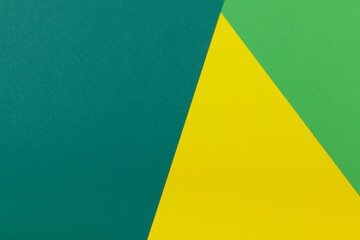 Multicolor background from a paper of different colors. Mix of yellow, green and dark green colors. Geometric backdrop.