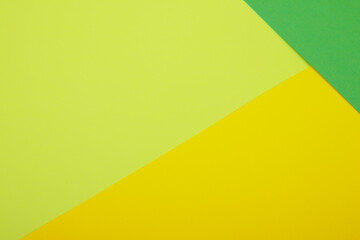 Multicolor background from a paper of different colors. Mix of yellow, green and lime colors. Geometric backdrop.
