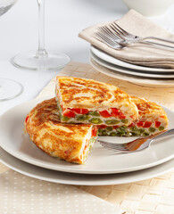 Red pepper, onion and asparagus omelette on a white plate.
