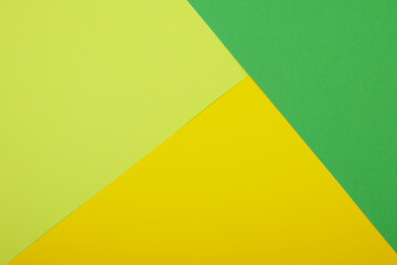 Multicolor background from a paper of different colors. Mix of yellow, green and lime colors. Geometric backdrop.