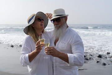 lifestyle of caucasian senior couple drinking champagne on beach, happy in love romantic and relax time, tourism of elderly family pleople, leisure and activity travel after retirement