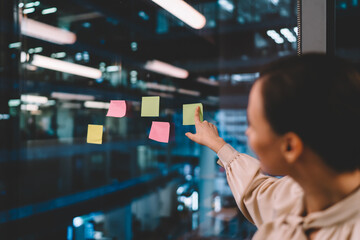 Female employee brainstorming with sticky notes in office
