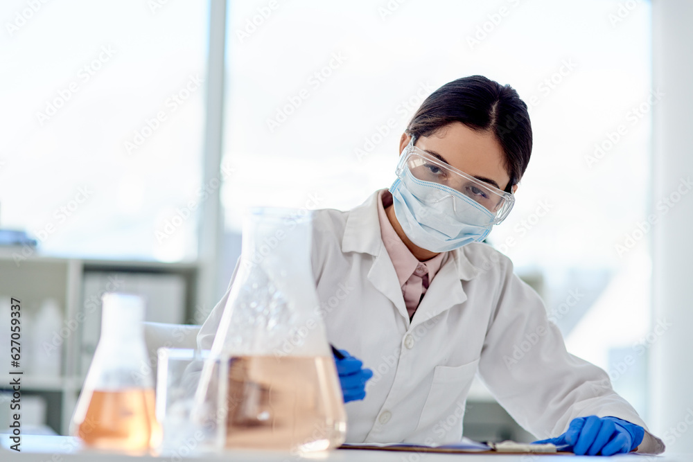 Poster Conducting another careful experiment. Shot of a young scientist doing an experiment in a lab.