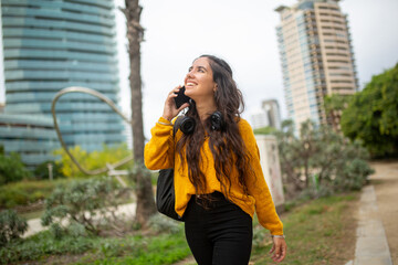 young woman walking and talking in city park