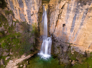 Waterfall and colorful water at sunrise. Photo long exposure silky water effect. Aerial photography. Castril. Andalusia. Spain.