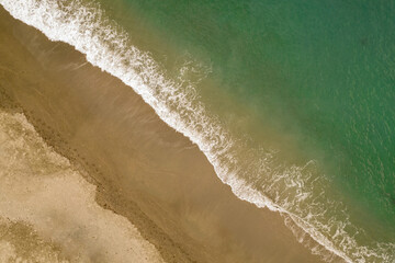 Coast line. Waves in the sand. Aerial view of waves on the beach. Textures and colors of sea and sand on the coast. Andalusia. Spain.