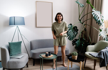 Adult woman standing in living room and laughing