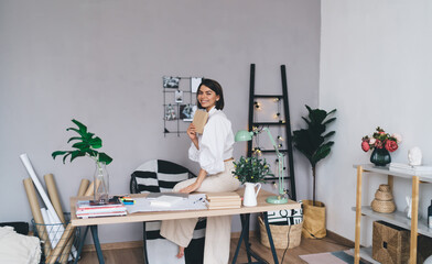 Cheerful female freelancer with notebook working in home office