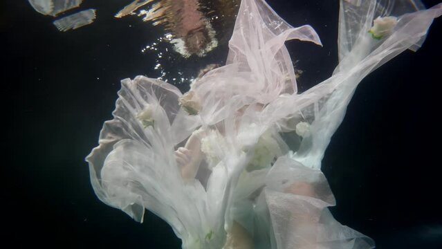 dreamy underwater shot with beautiful bride diving in dark depth of magical sea, romantic fairytale