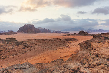 Red orange Mars like landscape in Jordan Wadi Rum desert, mountains background, overcast morning....