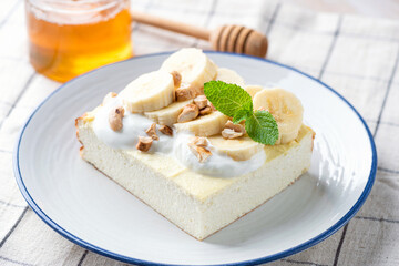 Sweet cottage cheese or ricotta cake served with cream and banana. Zapekanka