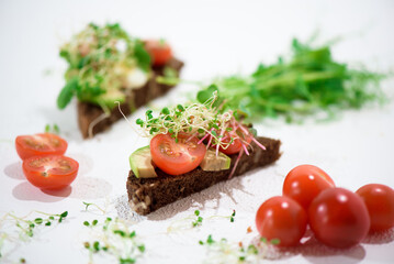 Fototapeta na wymiar Toasts with microgreens. Hand holds a healthy toast. Healthy food concept. Super food.
