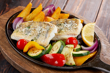 fish with grilled vegetables on the pan