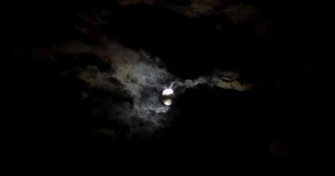 Across the night sky, moon moves.
