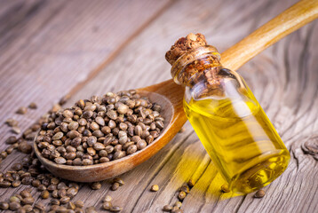 Hemp seeds and hemp seed oil on wooden background
