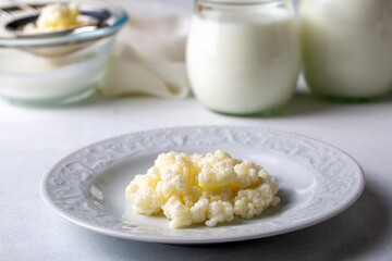 Kefir fermented milk drink with kefir grains. Homemade kefir stands in a glass, next to kefir grains and milk