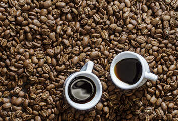 Two espresso cup on coffee beans background above