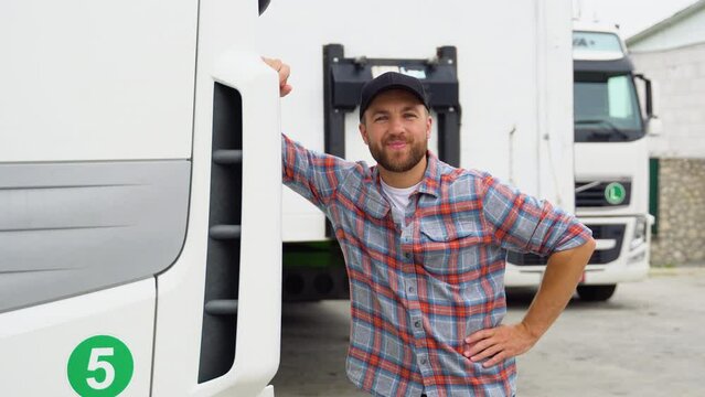 A smiling truck driver posing with trucks
