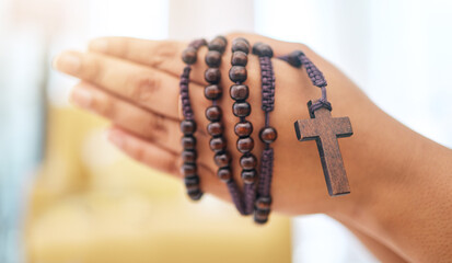 Rosary, praying and hands of woman with gratitude, faith or guidance in her home for help from...