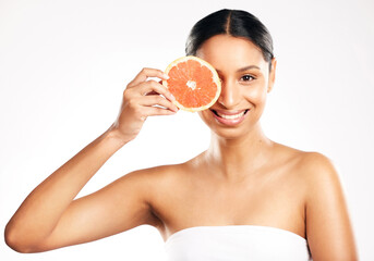 Happy woman, portrait and grapefruit for vitamin C, diet or skincare against a white studio background. Female person smile with organic fruit in healthy nutrition, natural beauty or facial treatment