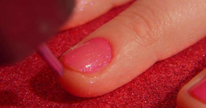 Close up of a woman Painting her hand Nails With Pink Polish