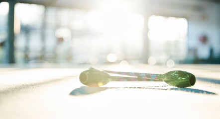 Fitness, dance and ribbon on the floor of a gym or studio for training with flare on a blurred background. Exercise, creative and equipment with a baton for dancing in an empty health center closeup