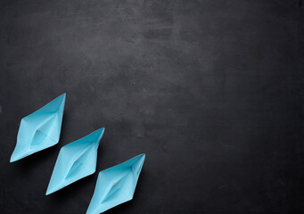 Three blue paper boats stand in a row, teamwork.