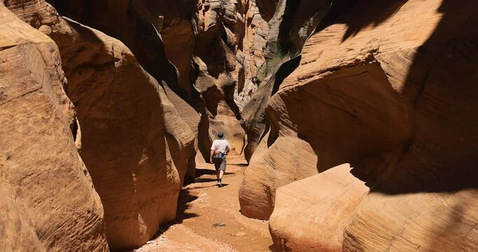 Utah desert rocky river slot canyon man hiking 4K. Southern Utah recreation hiking exploring. Grand Staircase Escalante National Monument, Willis Creek slot canyon. Wilderness environment.
