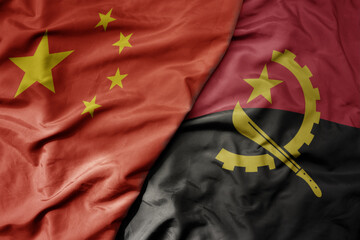 big waving national colorful flag of china and national flag of angola . - obrazy, fototapety, plakaty